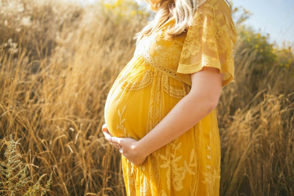 Femme enceinte posant avec son ventre à la maison.